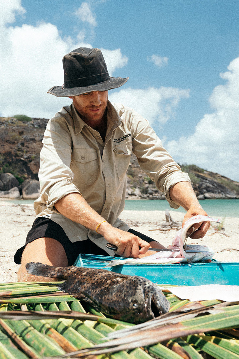 strick filleting a fish in his back 2 basics light weight fishing shirt on a tropical island