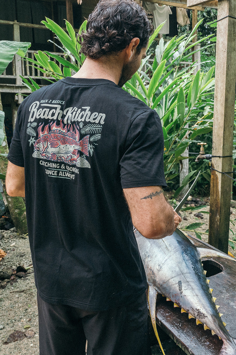 cutting a yellow fin tuna in a black beach kitchen back 2 basics shirt