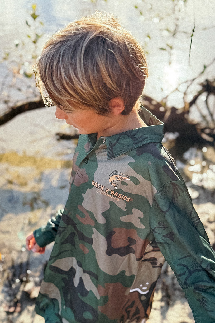 kid walking in mangroves wearing back 2 basics out here doing it camo with barramundi