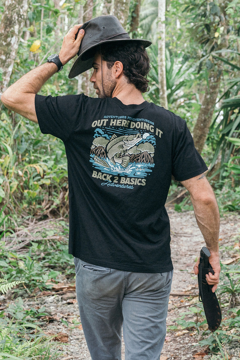 aaron from back 2 basics wearing a black tee shirt with a barramundi on it jumping out of the water chasing an insect